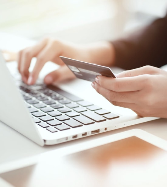 Person Holding a Credit Card And Working On A Laptop